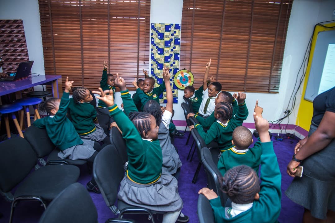 Children raising hands in class